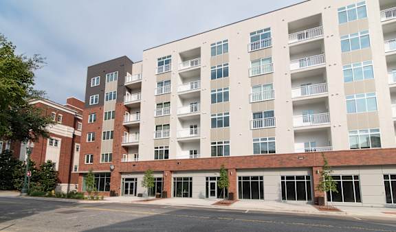 A large apartment building with a parking lot in front.