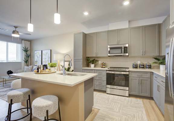 an open kitchen with a large island and stainless steel appliances