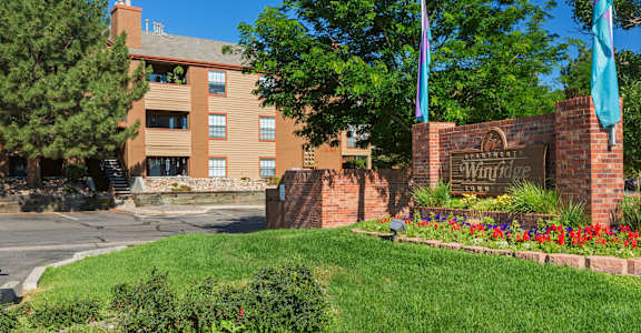 A brick sign that says Winridge in front of a building.
