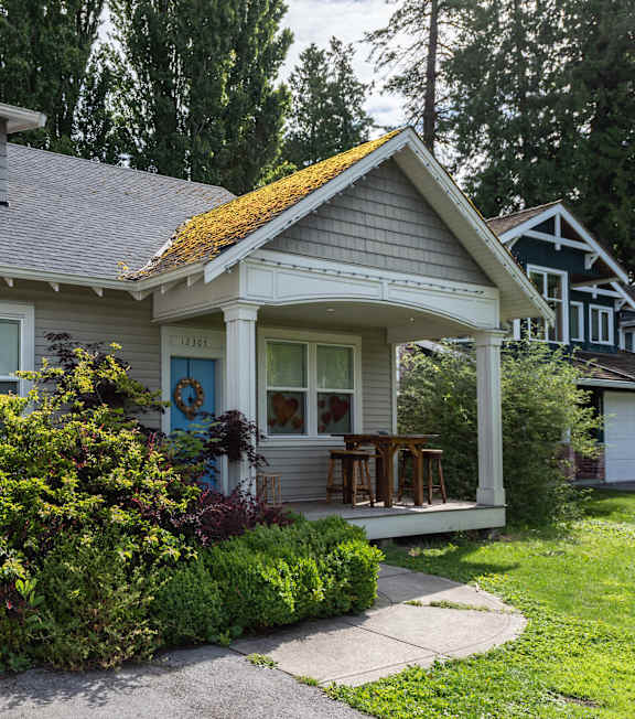 A house with a grey roof and a white front porch.