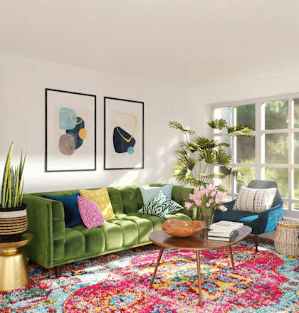 a living room with green furniture and a large rug
