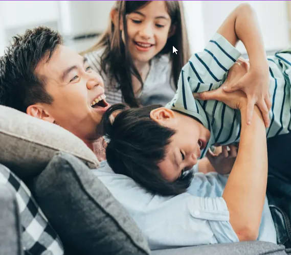 a man and a woman are sitting on a couch with a young boy and girl