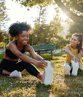 Two women stretching in a park at Victory Northgate Apartments, Seattle, WA