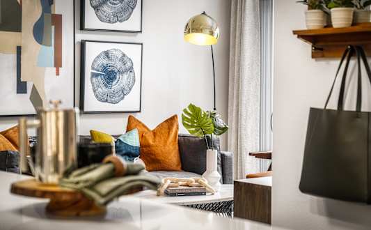 A living room with a couch, a table, and a lamp.
