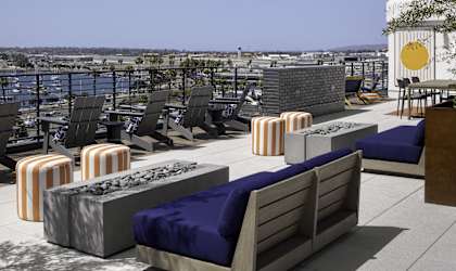 a rooftop patio with couches and tables and a view of the city