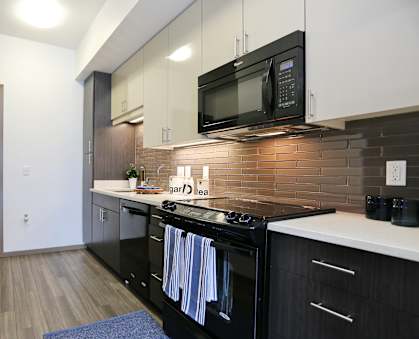 a kitchen with white countertops and black appliances