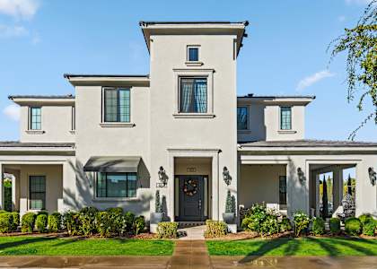 A large, two-story house with a front yard and a driveway.
