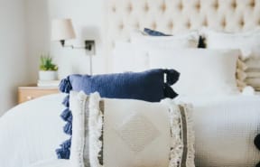 a bed with a white and blue bedspread and pillows