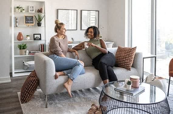 a living room with a kitchen and a table and chairs