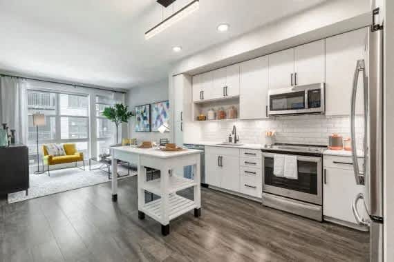 A modern kitchen with a white island and stainless steel appliances. at Coda at Bryant Street, Washington, DC 20002