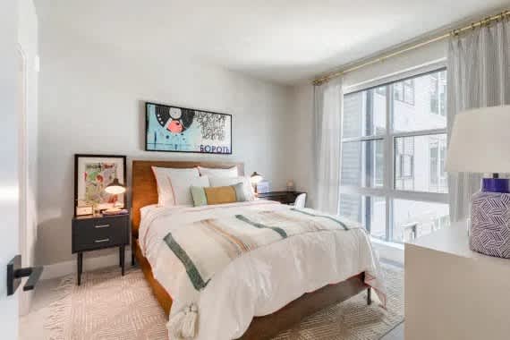 A bedroom with a large bed and a painting on the wall. at Coda at Bryant Street, Washington, DC 20002