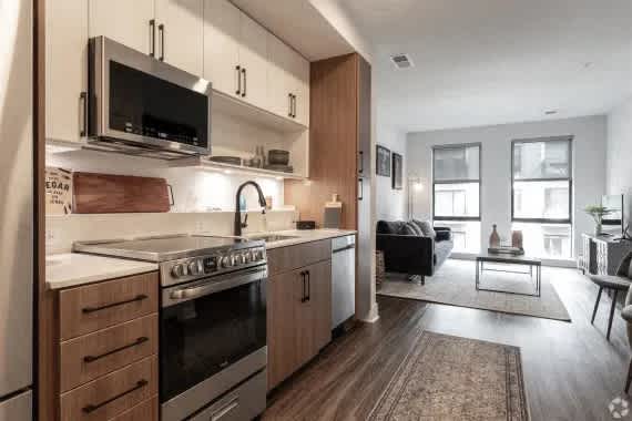 A modern kitchen with stainless steel appliances and wooden cabinets. at Coda at Bryant Street, Washington, DC 20002