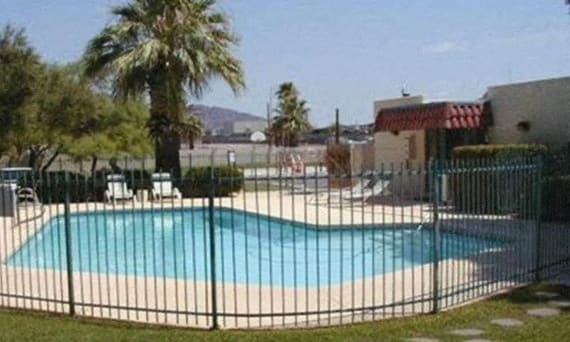 a swimming pool with a wrought iron fence around it