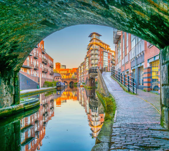 a city with a canal and buildings reflected in the water