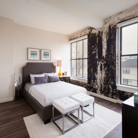 a bedroom with a bed and a damaged wall