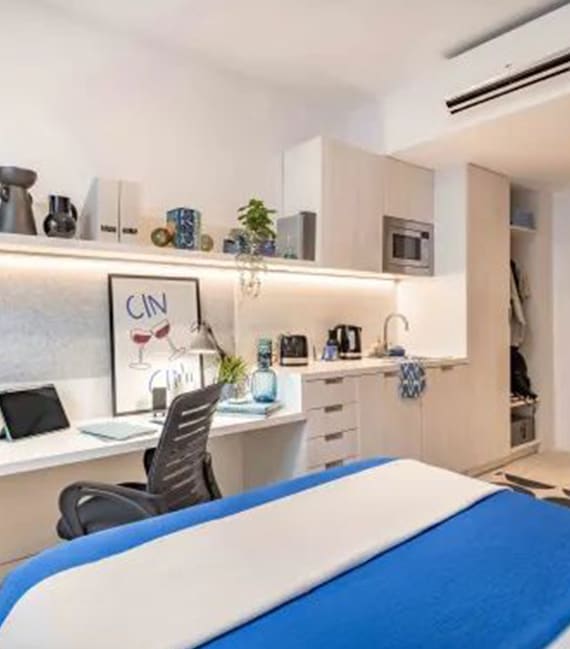 a small bedroom with a desk and a bed