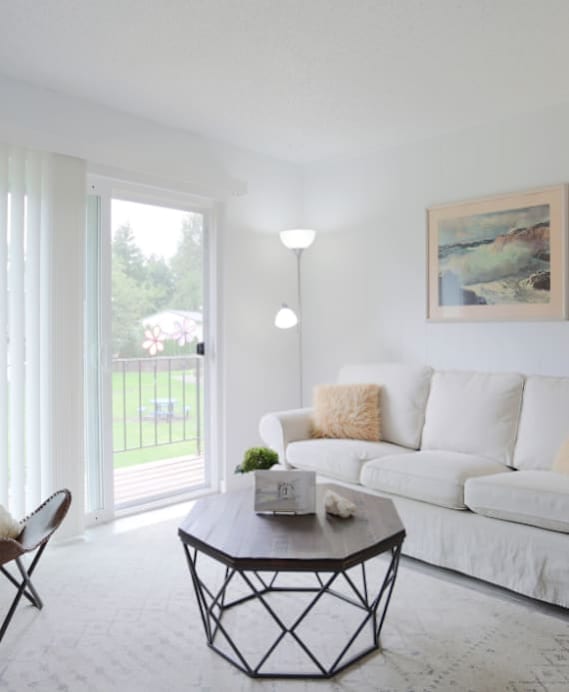 A white couch with a brown chair and a black coffee table.at Tigardville Apartments, Tigard, 97223