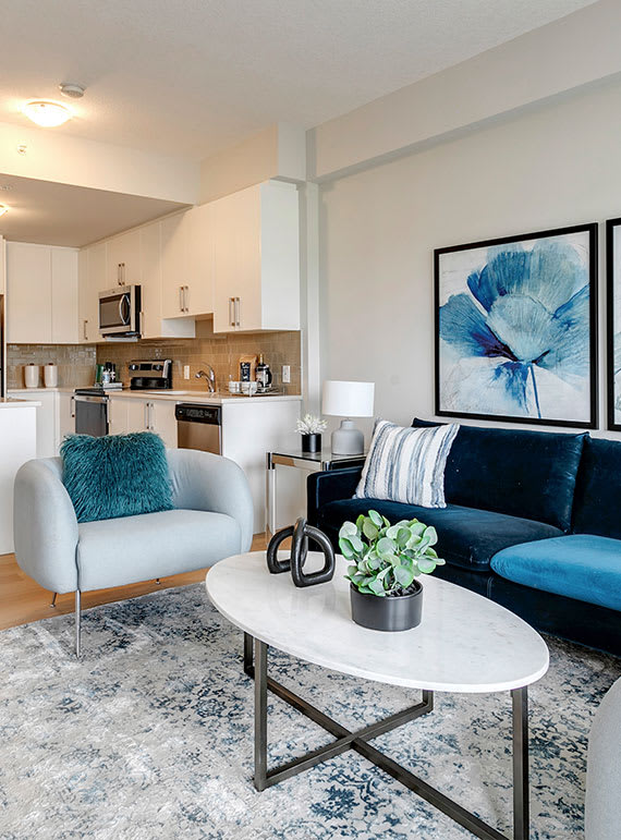 a living room with a blue couch and a white coffee table