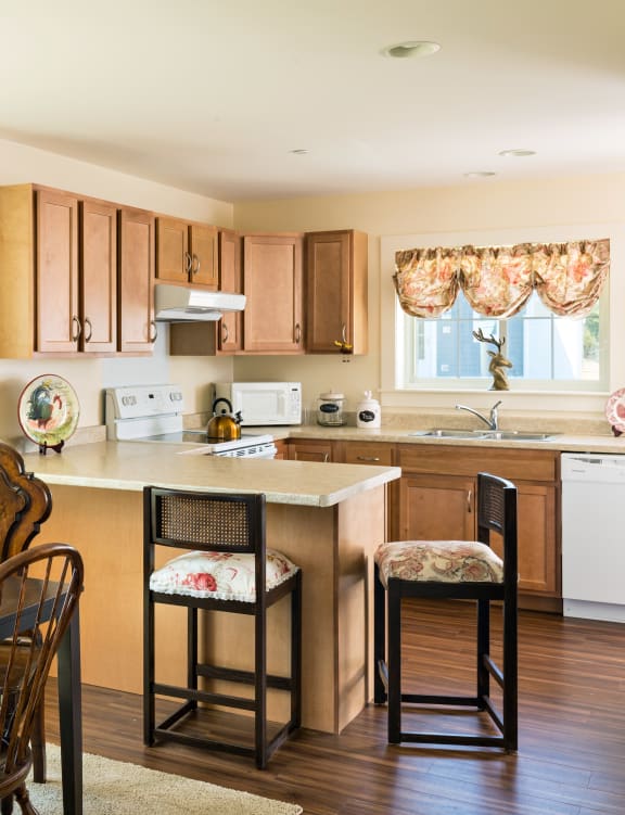 a kitchen with wooden cabinets and a table and a window