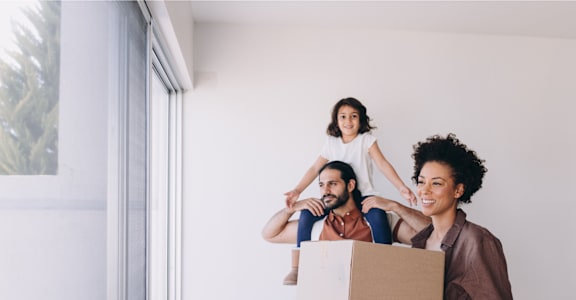 a group of people moving into a house with a box at Tides on Southern, Mesa, AZ