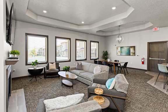 A living room with grey and white furniture and a fireplace.