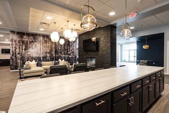 A modern kitchen with a long counter and a wall of cabinets.
