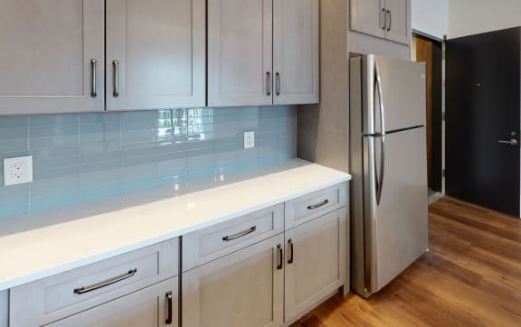 a kitchen with white cabinets and a stainless steel refrigerator