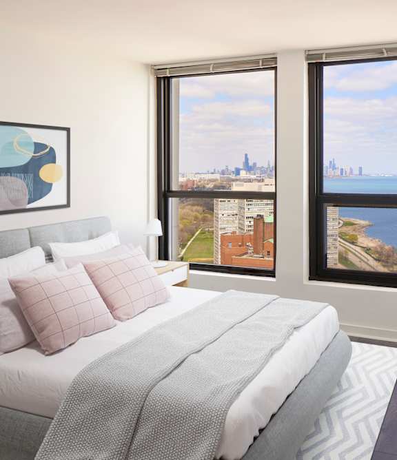 A bedroom with a large bed and a view of the city.