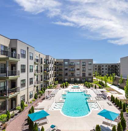 A large swimming pool surrounded by apartment buildings.