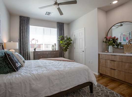 a bedroom with a large bed and a ceiling fan