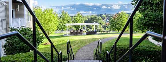 a view of a park with a gazebo in the distance and stairs
