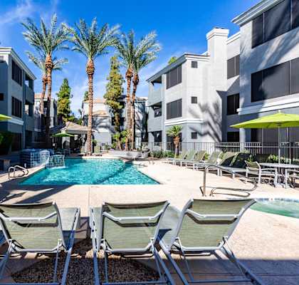 A pool surrounded by chairs and umbrellas.