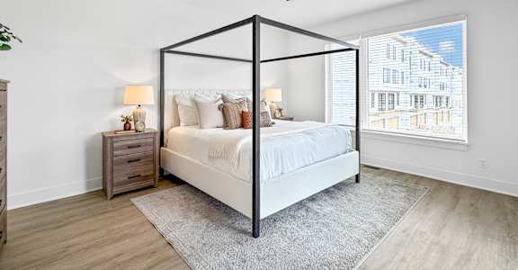 A bedroom with a four poster bed and a ceiling fan.