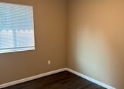 Thumbnail 33 of 48 - A room with a window and wooden flooring.