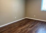 Thumbnail 45 of 48 - A room with a window and wooden flooring.