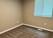 Thumbnail 25 of 48 - A room with a window and a brown carpet.