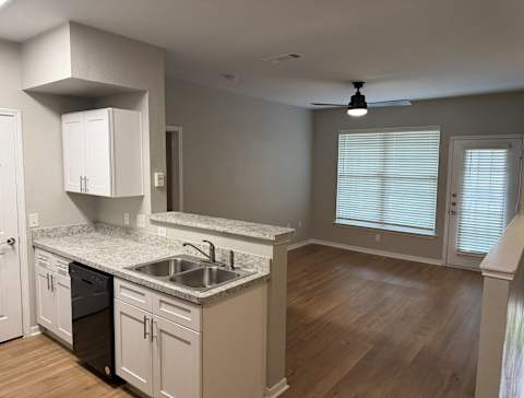 Park at Kirkstall 1-bed kitchen with a sink and living area with a window.