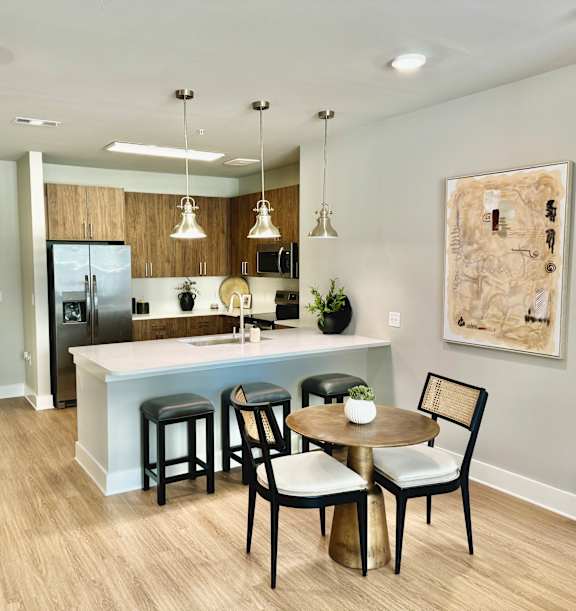 A kitchen with a bar and chairs at The Collective Upper Westside Apartments, Atlanta, GA, 30318