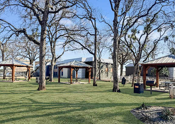 A park with a gazebo and picnic tables.