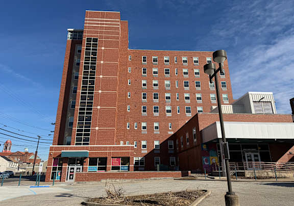 A large red brick building with a parking lot in front.