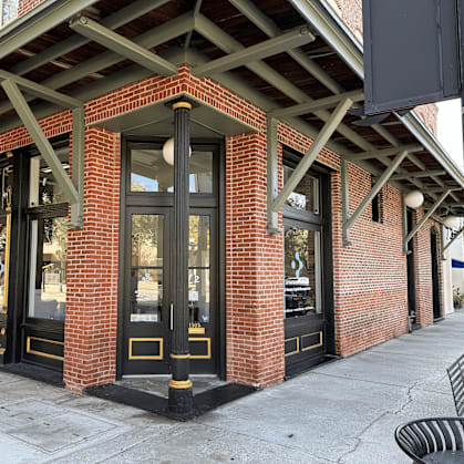 A building with a red brick facade and black doors.
