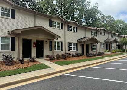 A row of houses with a parking lot in front at Waverly Manor Townhomes, Norcross, GA 30071