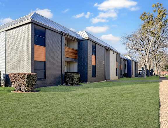 A modern building with a grey facade and orange windows.