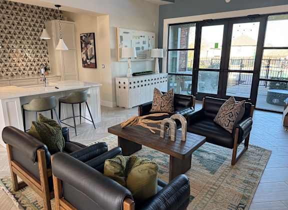 A living room with a black leather couch and a wooden coffee table.