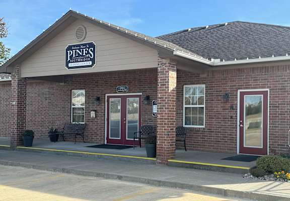 A building with a sign that says Pines on it.