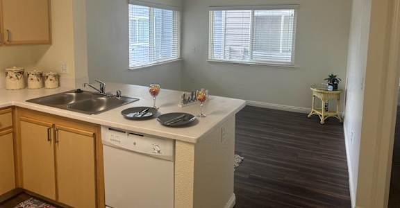 A kitchen with white appliances and wooden cabinets.