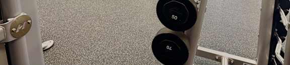A gym with a variety of equipment including dumbbells and weight plates.
