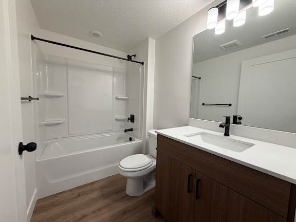 A white bathroom with a toilet, sink, and shower.
