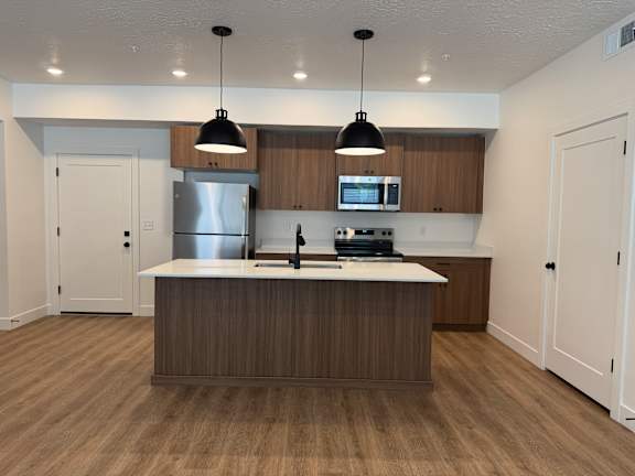 A modern kitchen with wooden cabinets and a center island.