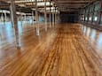 A large room with wooden floors and pillars.